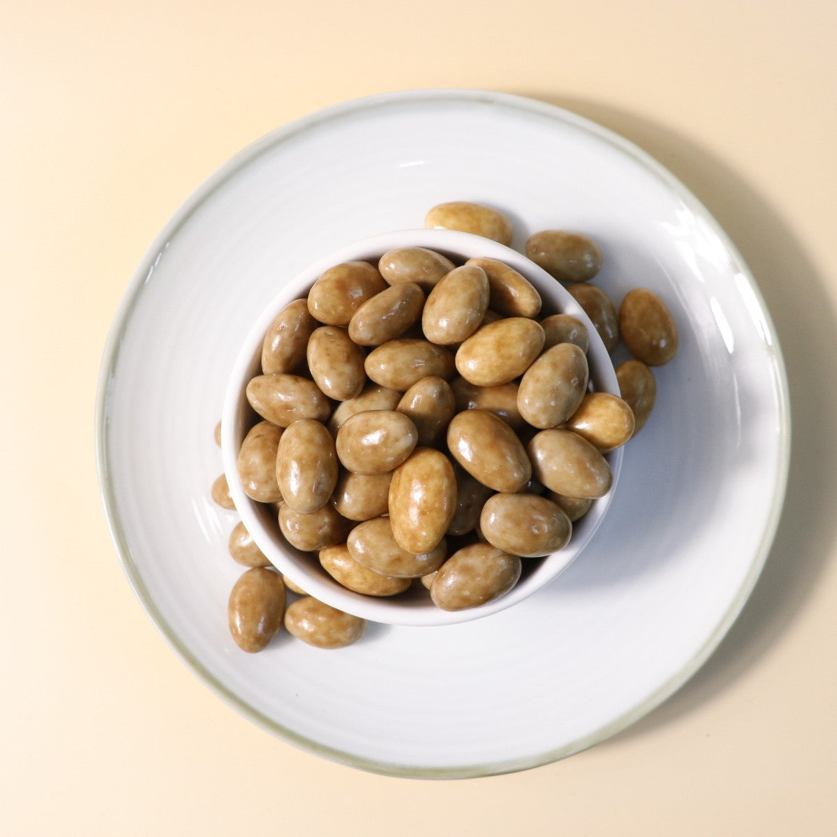 Yathrib Premium Caramel Almond Dragee showcasing shiny caramel-coated almonds on a white background