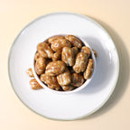 Yathrib Caramel Pecan Dragee showing glossy caramel-coated pecans on a white background