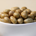 Yathrib Caramel Pistachio Dragee with glossy caramel coating and visible pistachio nuts on a white background