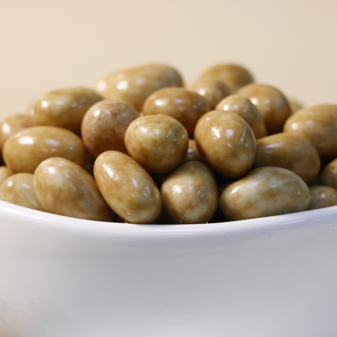 Yathrib Caramel Pistachio Dragee with glossy caramel coating and visible pistachio nuts on a white background