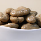 Yathrib Coffee Pecan Dragee close-up showing glossy coated pecans with coffee-flavored coating on a white background