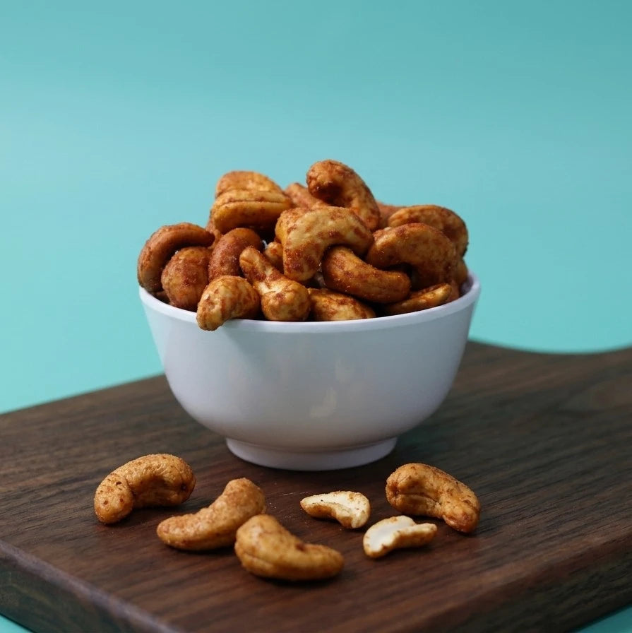 Spicy chili roasted cashews by Yathrib in a bowl, showcasing crunchy, spicy snack nuts with red chili seasoning.