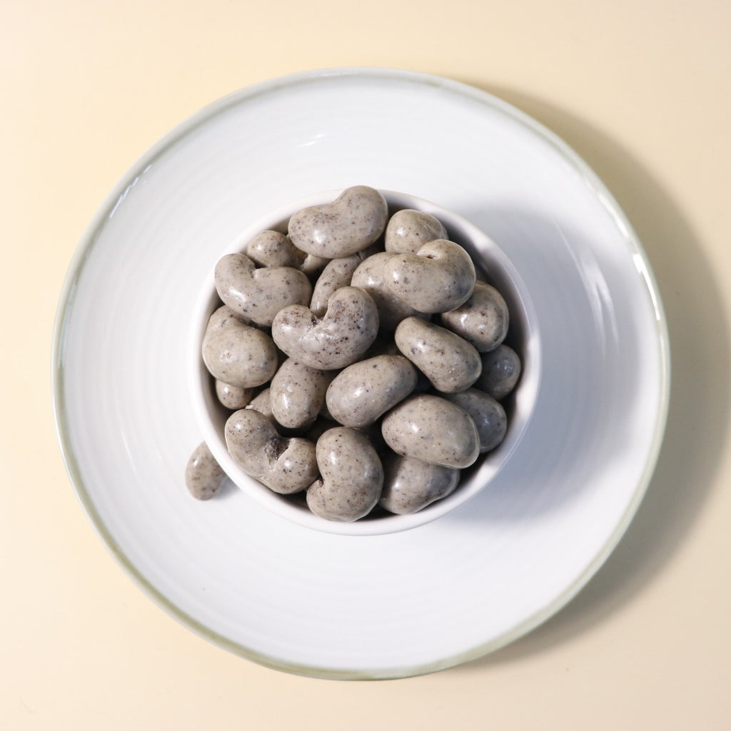 Yathrib Creamy Chocolate Cashew Dragee with smooth chocolate coating and crunchy cashew nuts inside, presented in a close-up shot.