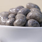 Creamy chocolate cashew dragee by Yathrib, showing glossy chocolate-coated cashews in a close-up image.