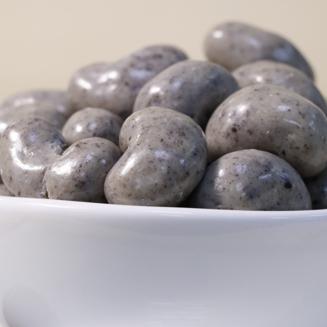 Creamy chocolate cashew dragee by Yathrib, showing glossy chocolate-coated cashews in a close-up image.