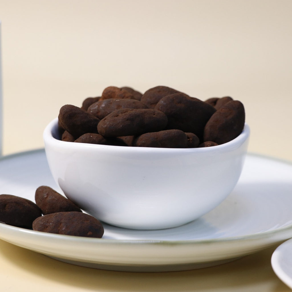 Yathrib dark chocolate pecan dragee featuring glossy chocolate coating and crunchy pecans on a white background