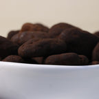 Yathrib dark chocolate pecan dragee showing glossy chocolate coating and crunchy pecans on a white background.