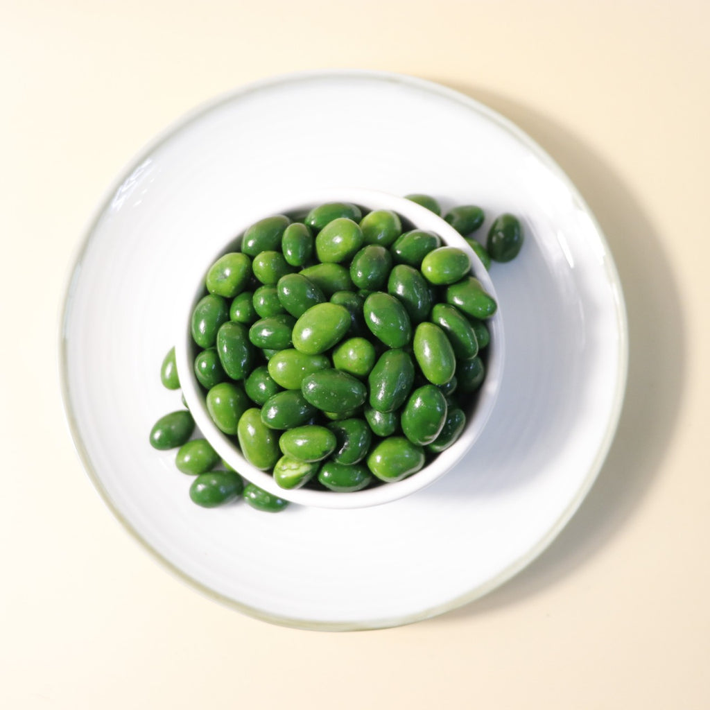 Yathrib Premium Matcha Pistachio Dragee showing green matcha-coated pistachio candies on a white background.