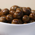 Yathrib classic milk chocolate cashew dragee showing glossy milk chocolate coating and crunchy cashew nuts inside.