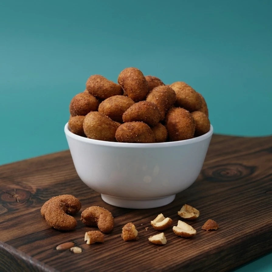 Yathrib Chili Kri-Kri Cashews in a bowl, showing spicy, roasted cashews with red chili seasoning on a white background.