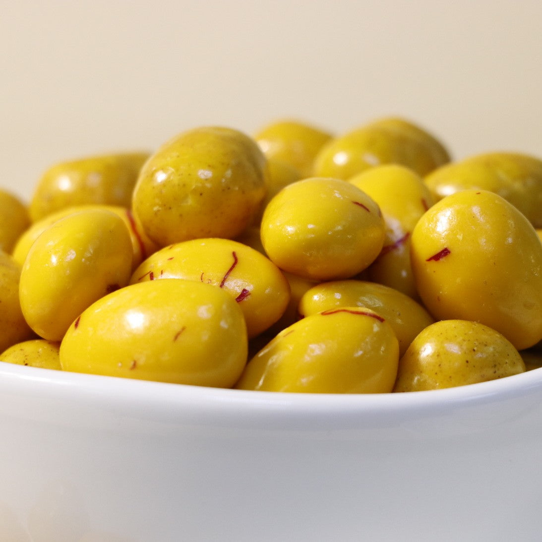 Yathrib Saffron Almond Biscuit Dragee showcasing golden saffron-infused biscuits with almonds and a glossy coating, close-up view