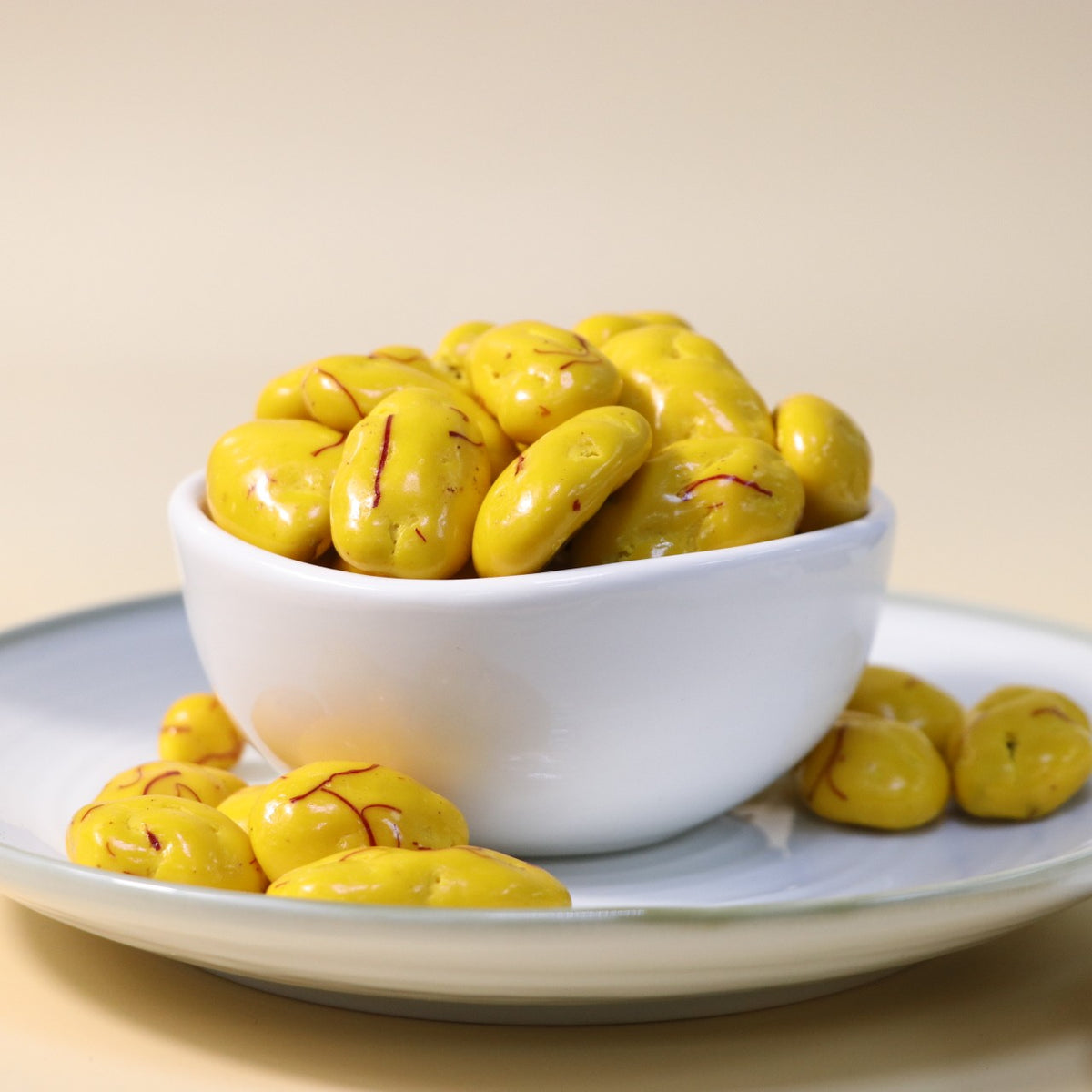 Yathrib saffron pecan dragee featuring glossy golden caramel coating with visible pecan pieces inside