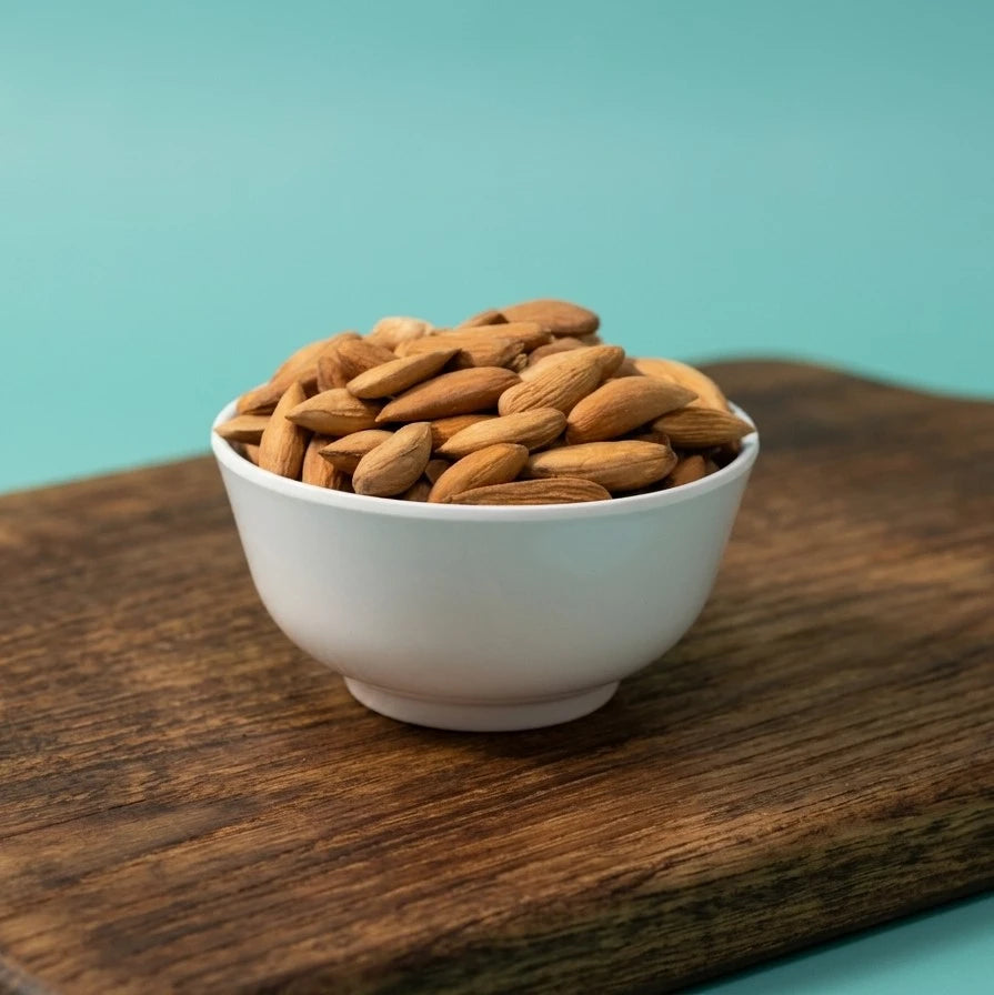Yathrib Mamra Almonds from Afghanistan in a bowl, showcasing their rich, natural texture and smooth shell.