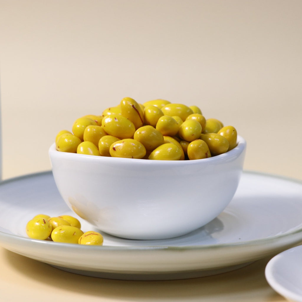 Yathrib saffron pistachio dragee with golden coating and visible pistachio nuts, showcasing a luxurious confectionery treat.
