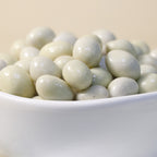 Yathrib white chocolate pistachio dragee featuring a glossy white chocolate coating and crunchy pistachio center.