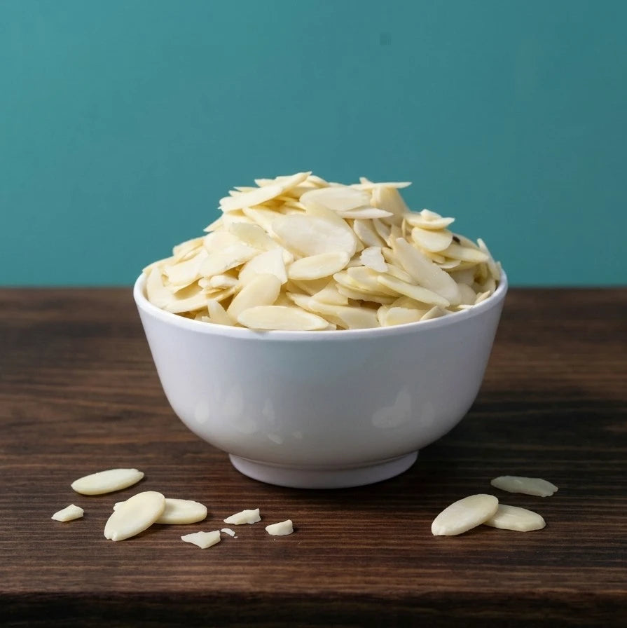 Sliced almonds from Yathrib, showing thin, light brown almond slices spread out on a neutral background.